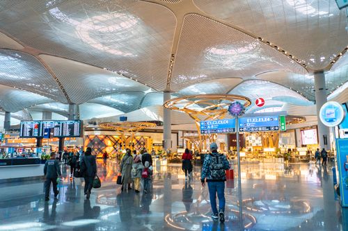 Free Spacious airport interior with travelers, shops, and architectural details. Stock Photo