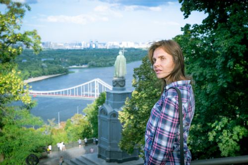 Free Woman enjoying panoramic view from Volodymyr Hill in Kyiv, featuring a bridge and river. Stock Photo