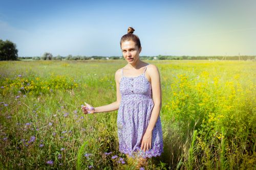 Free A young woman in a floral dress stands in a sunny meadow in Kherson, Ukraine, surrounded by wildflowers. Stock Photo