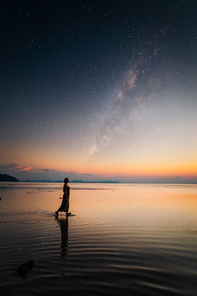 Woman Walking On Beach At Night