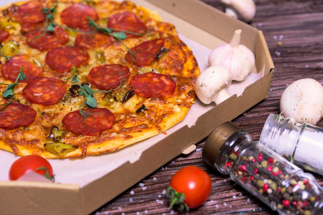 Free Pizza With Tomato and Basil on Brown Box Stock Photo