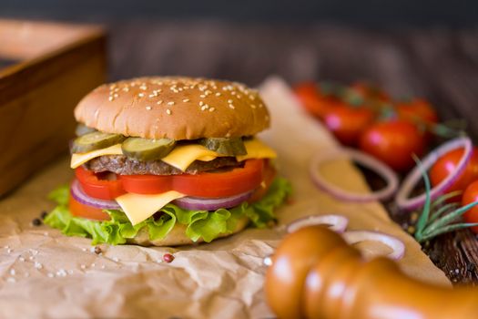 Mouthwatering homemade cheeseburger with fresh vegetables and sesame seed bun.