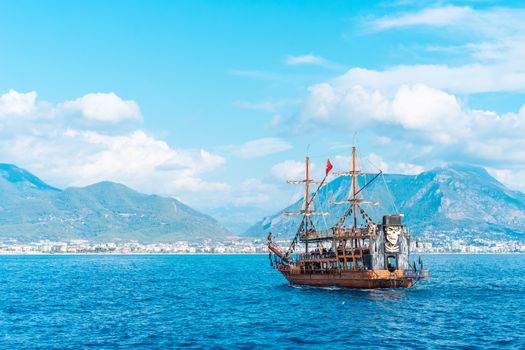 A traditional pirate ship sailing along Alanya's scenic coastline in Turkey.
