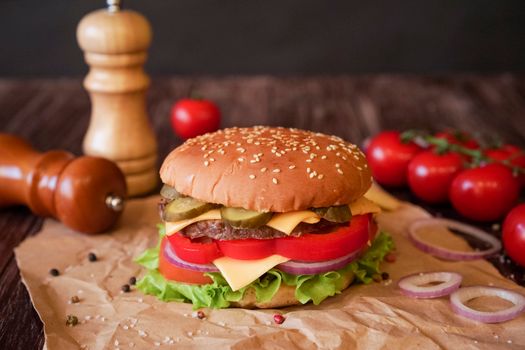 Delicious cheeseburger with pickles, onions, tomatoes, and lettuce on a sesame bun.