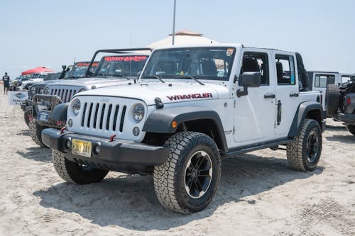 Row of Jeep Wrangler Cars Parked on Sand