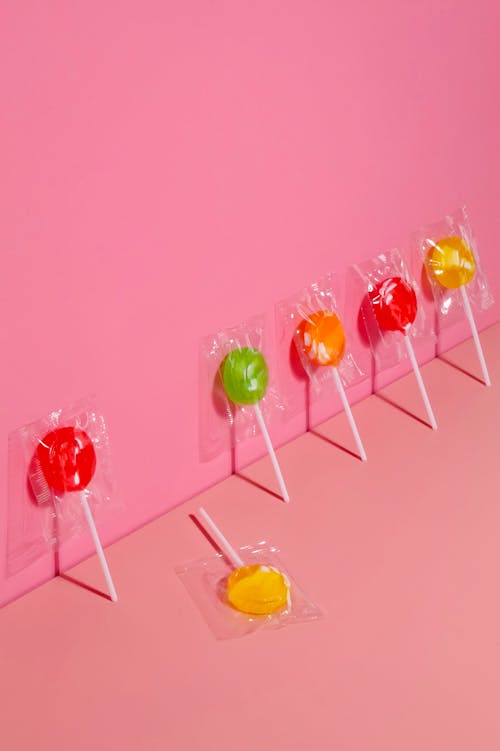 Lollipops Against a Pink Wall and One Lying