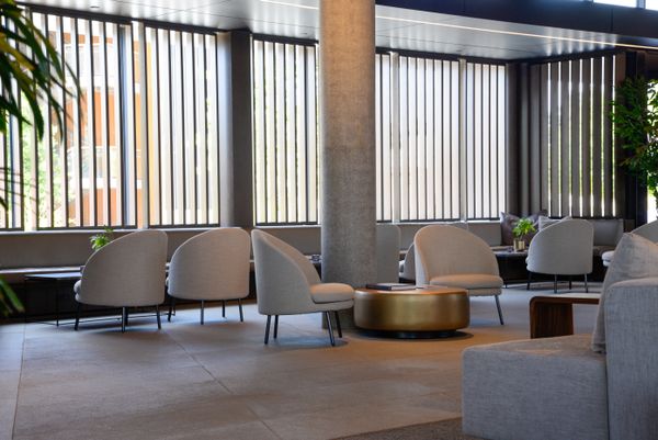 Ground-floor lounge with linen armchairs and a low brass table. Photo by Andrew Patrick Photo on Pexels.