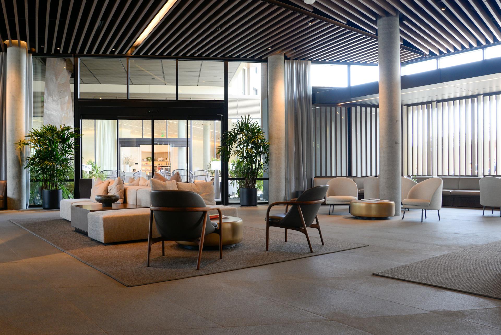 Spacious hotel lobby featuring contemporary furniture and natural lighting.