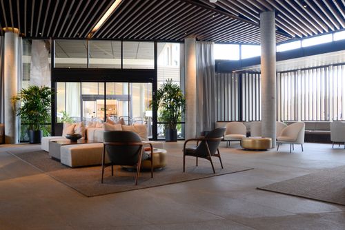 Free Spacious hotel lobby featuring contemporary furniture and natural lighting. Stock Photo