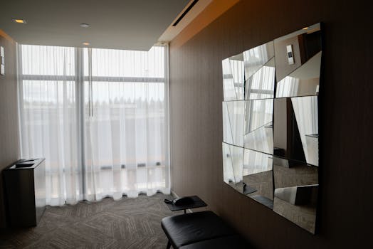 Sleek apartment interior featuring a large window and geometric mirror art.