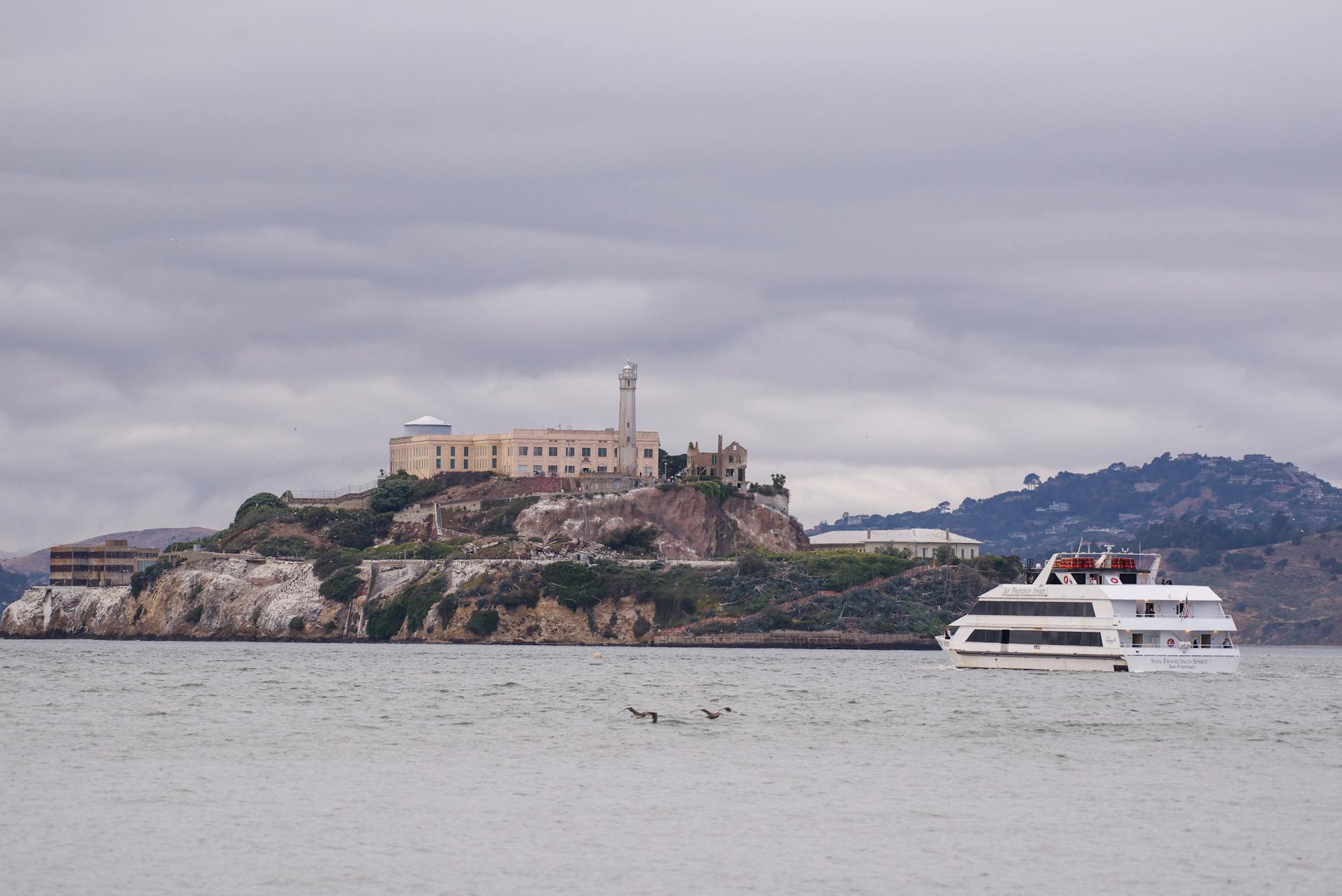 View of Alcatraz Island with a ferry on an overcast day in San Francisco Bay, California.