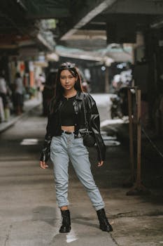 Fashionable teen posing in urban setting with casual outfit.