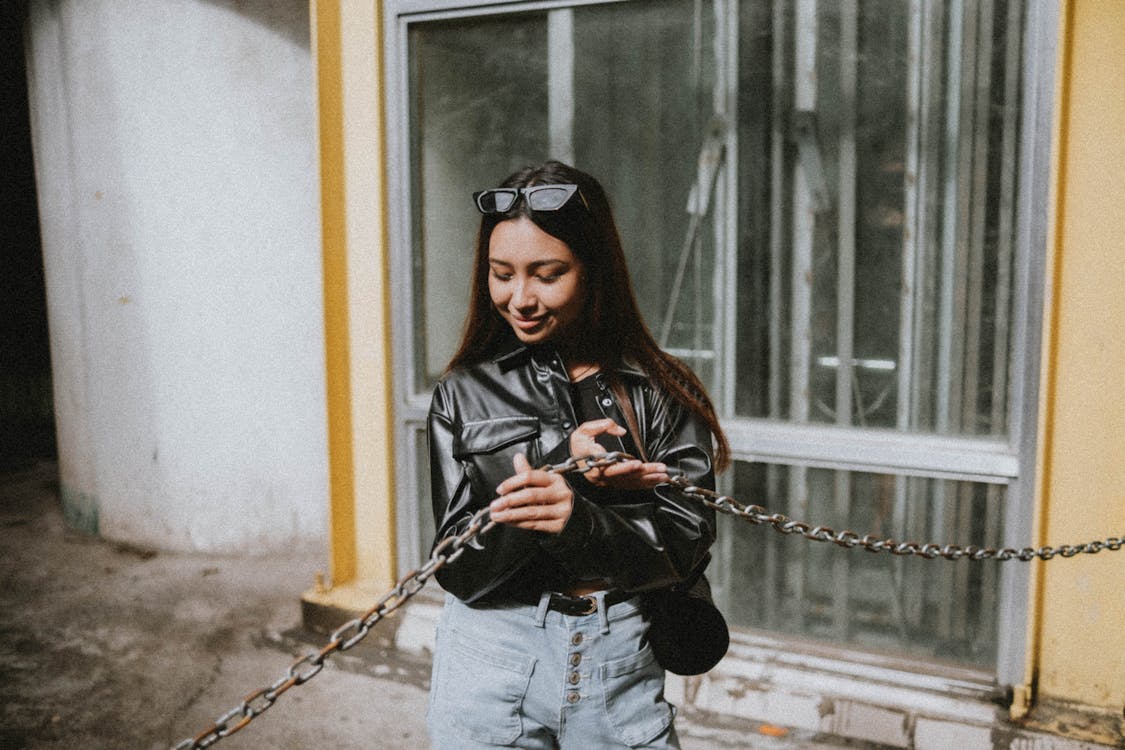 Woman in Black Leather Jacket Holding Metal Chain · Free Stock Photo