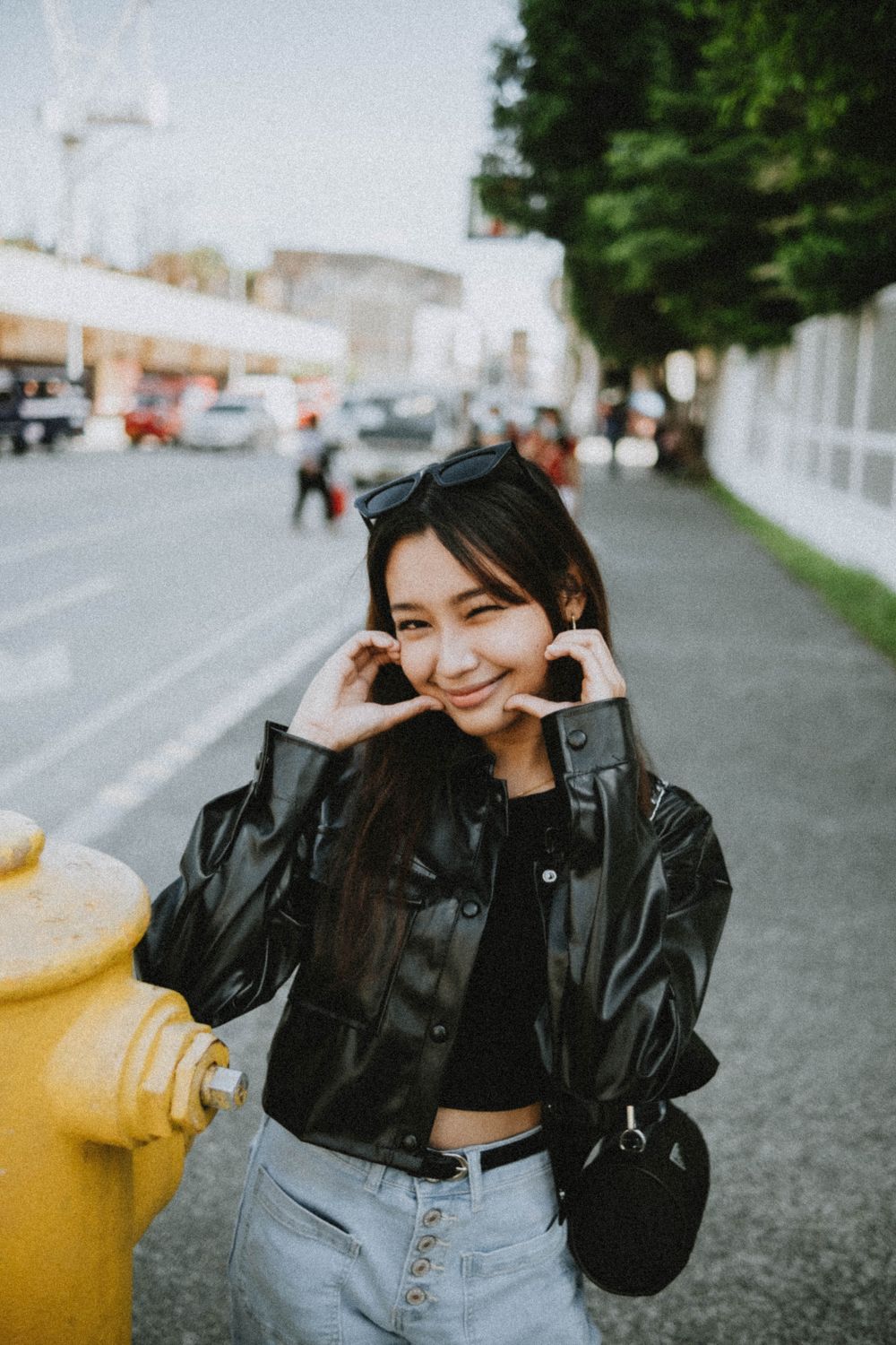 Smiling Woman in Black Leather Jacket Standing on Sidewalk · Free Stock ...