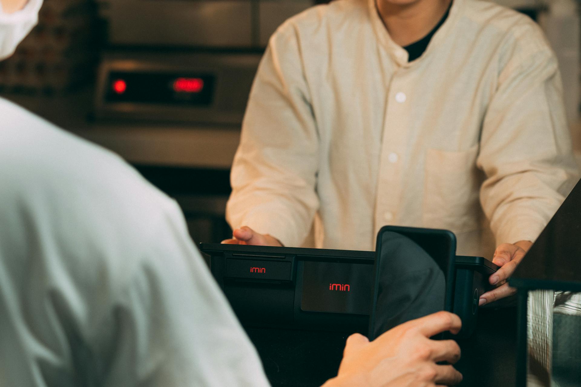 Digital payment using smartphone at a modern POS terminal indoors.