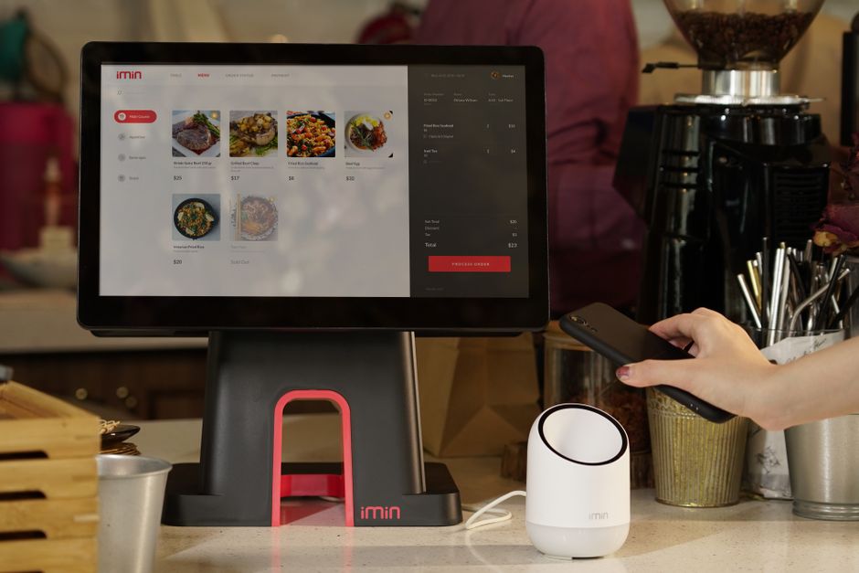 A modern point of sale system with contactless payment capability in a cafe setting. A modern point of sale system with contactless payment capability in a cafe setting.