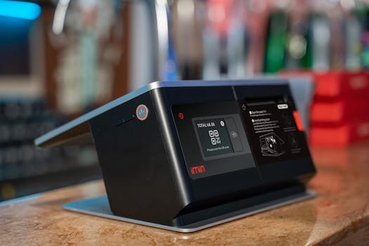 Close-up of a modern touchscreen payment terminal on a counter in a retail setting.