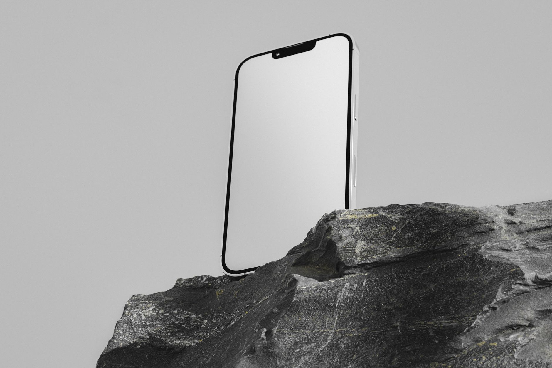Modern smartphone with blank screen displayed on a rugged rock, perfect for tech presentations.