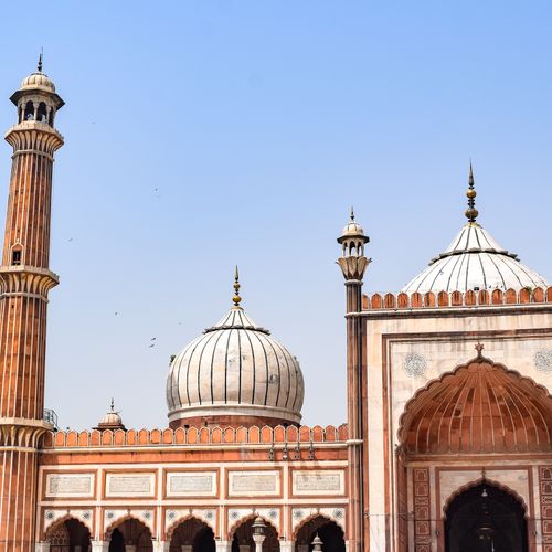 Free A view of the iconic domes and minaret of Jama Masjid in Delhi against a clear sky. Stock Photo