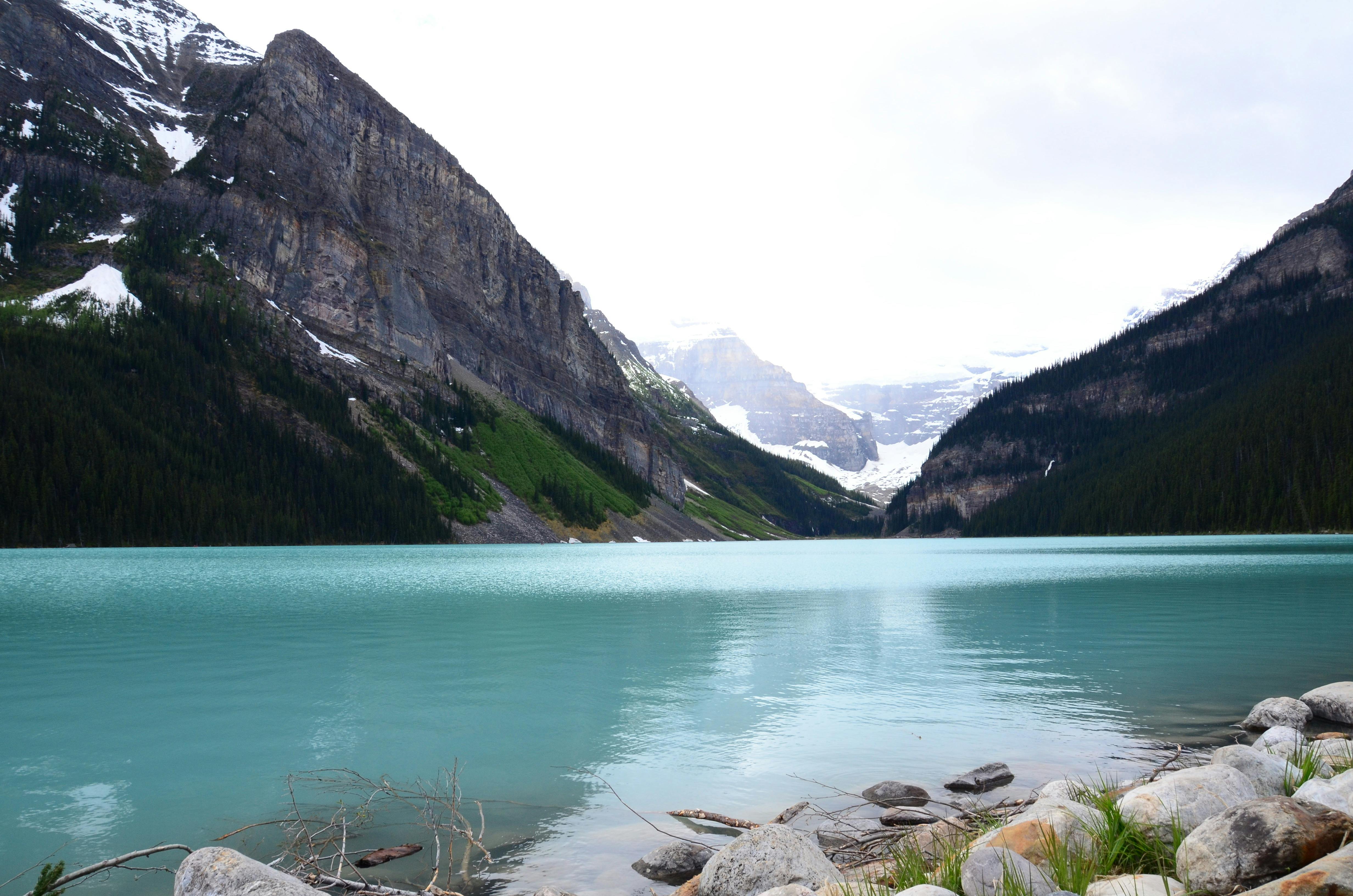 Body of Water Near Mountain Peaks · Free Stock Photo