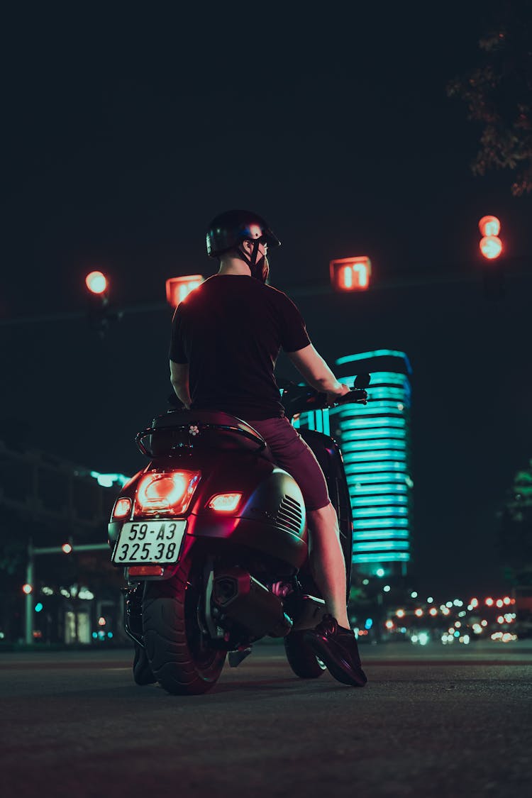 A Man Riding A Motorcycle At Night