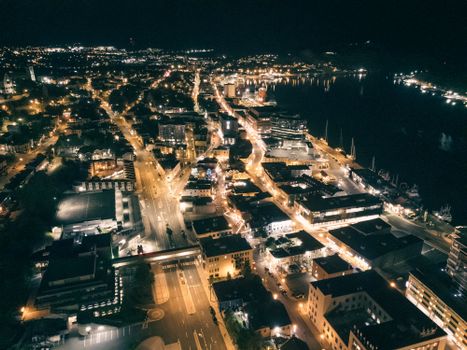 Stunning aerial view of a brightly lit cityscape at night with bustling streets and illuminated buildings.