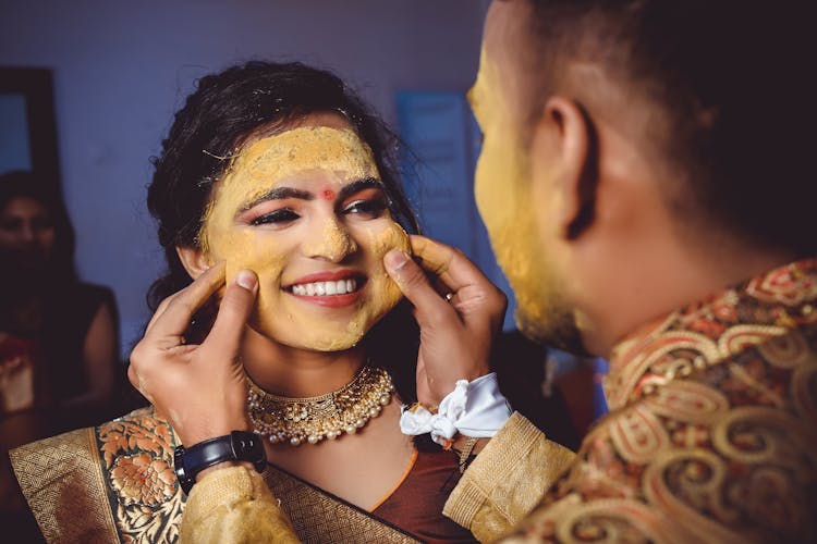 A Man Pinching The Cheeks Of His Wife