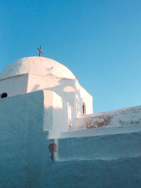 Capture of a classic white church dome under a clear blue sky in Folegandros, Greece.