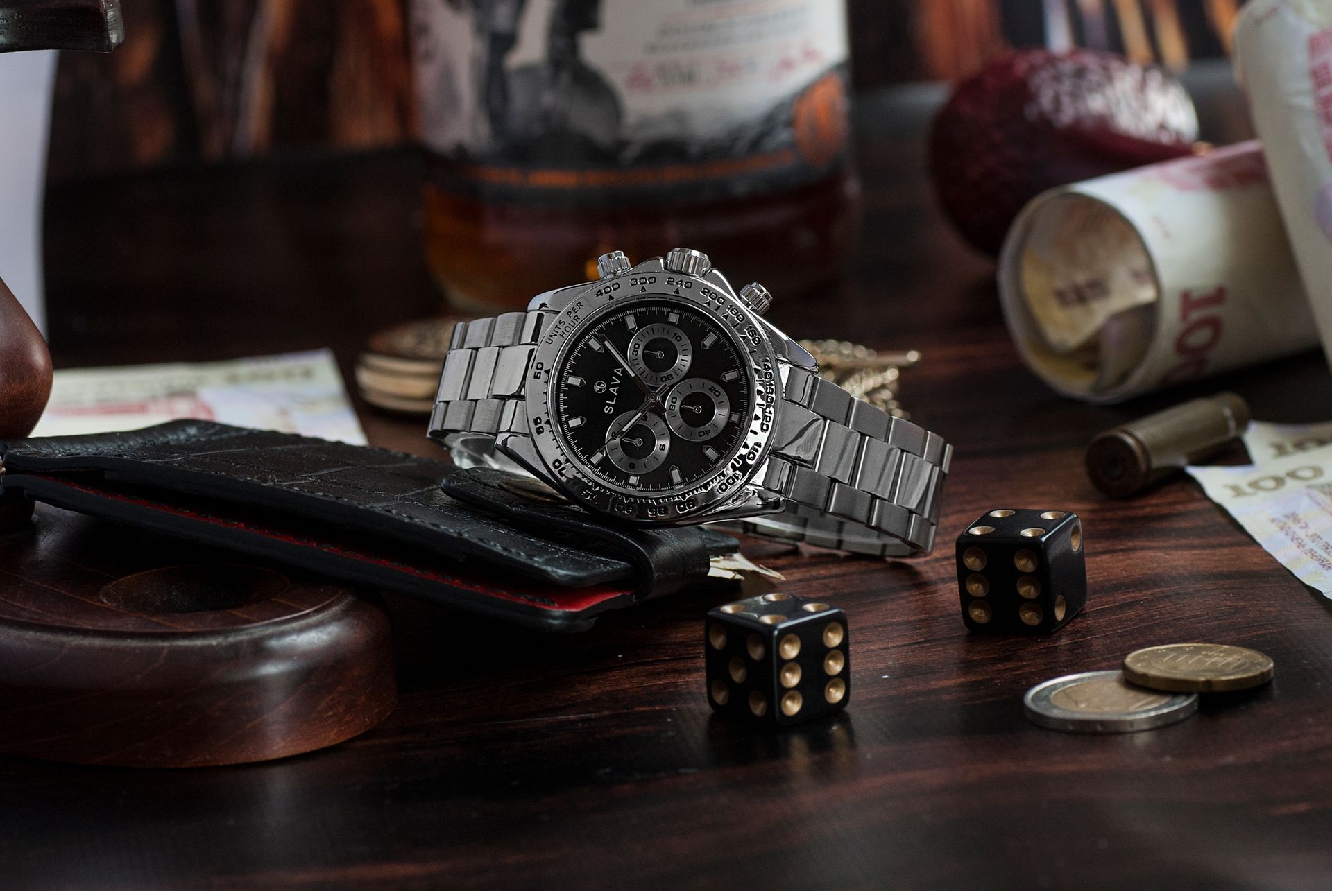 Elegant wristwatch among dice, coins, and banknotes, highlighting luxury and gambling themes.