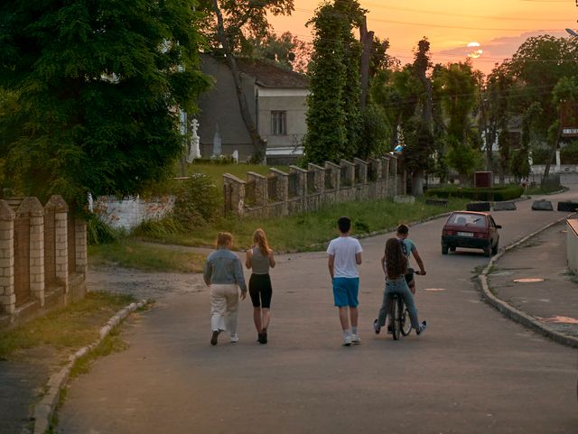 Teenagers walking a village road at sunset — photo by Denys Cherechecha on Pexels