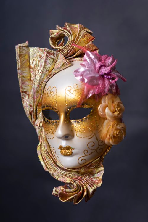 Free Close-up of an ornate Venetian masquerade mask adorned with gold and flowers. Stock Photo