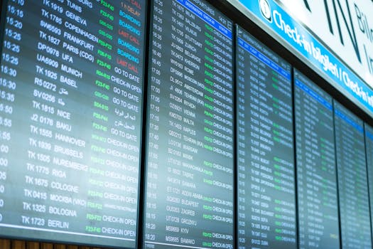 Digital screens display flight information and schedules at an airport terminal.