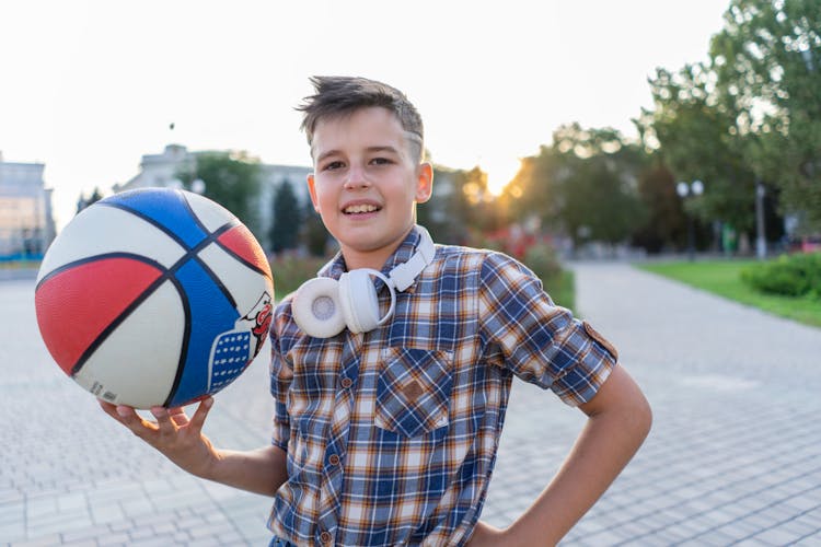 Portrait Of Boy With Basketball And Earphones