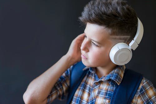 Foto profissional grátis de criança, escutando, fones de ouvido