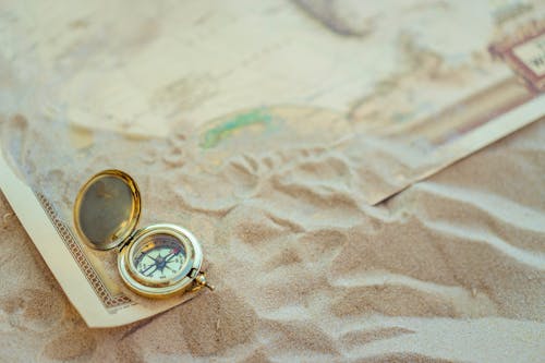 Compass and a Map in Sand 