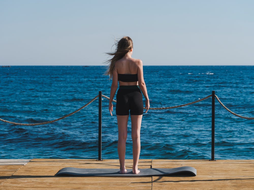 on Woman Blue Beside A Mat Stock Free a in Sea · Photo Yoga a Standing Black Sportswear