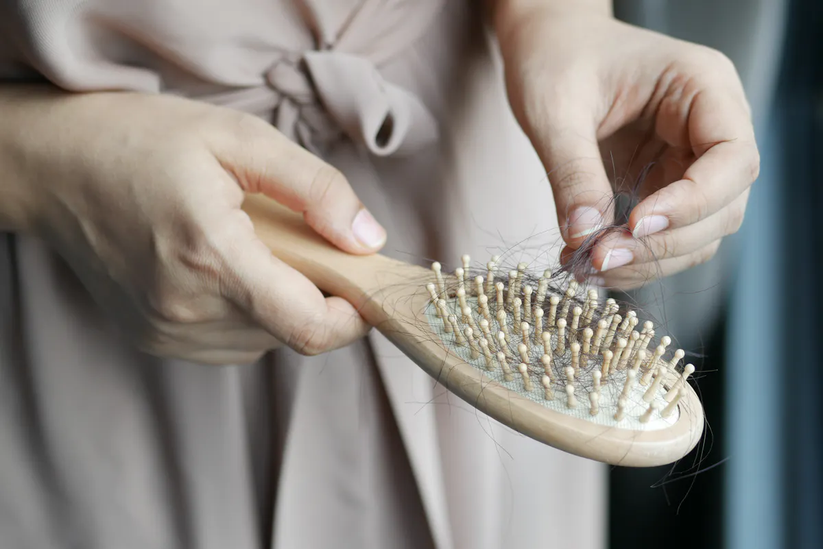 Close-up of a hairbrush with hair, unrelated to leg waxing or smooth legs.