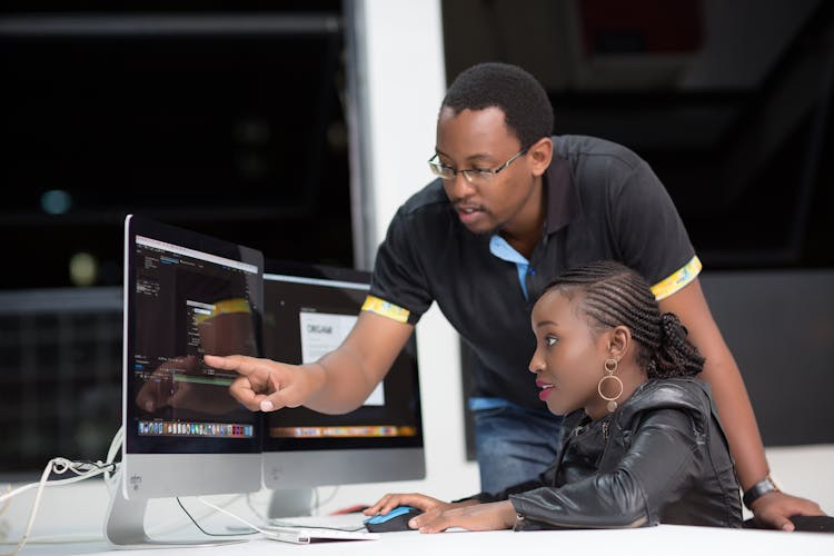 A Mentor Teaching A Student How To Edit A Video