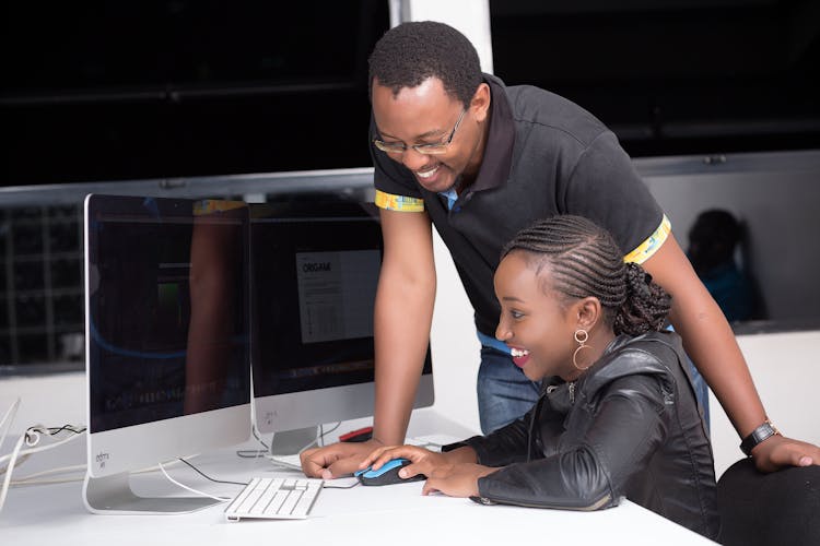 Man And A Girl Laughing And Working At A Computer