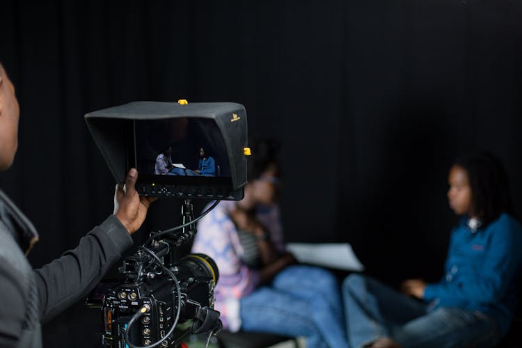 Man Filming Two Talking To Each Other Women 