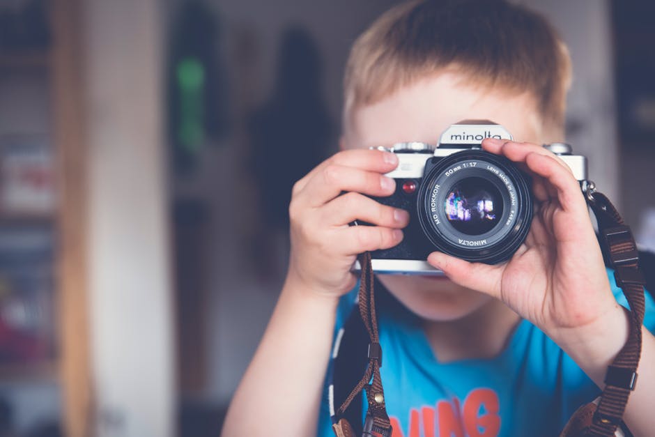 Boy in Blue Crew Neck T Shirt Taking Photo Using Minolta Dslr Camera