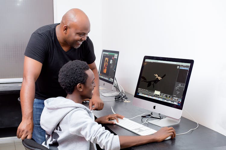 Teacher And Student Looking At A Computer Screen 