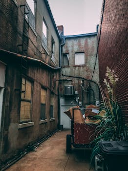 探索一条有复古砖墙和废弃手推车的狭窄城市小巷的建筑魅力