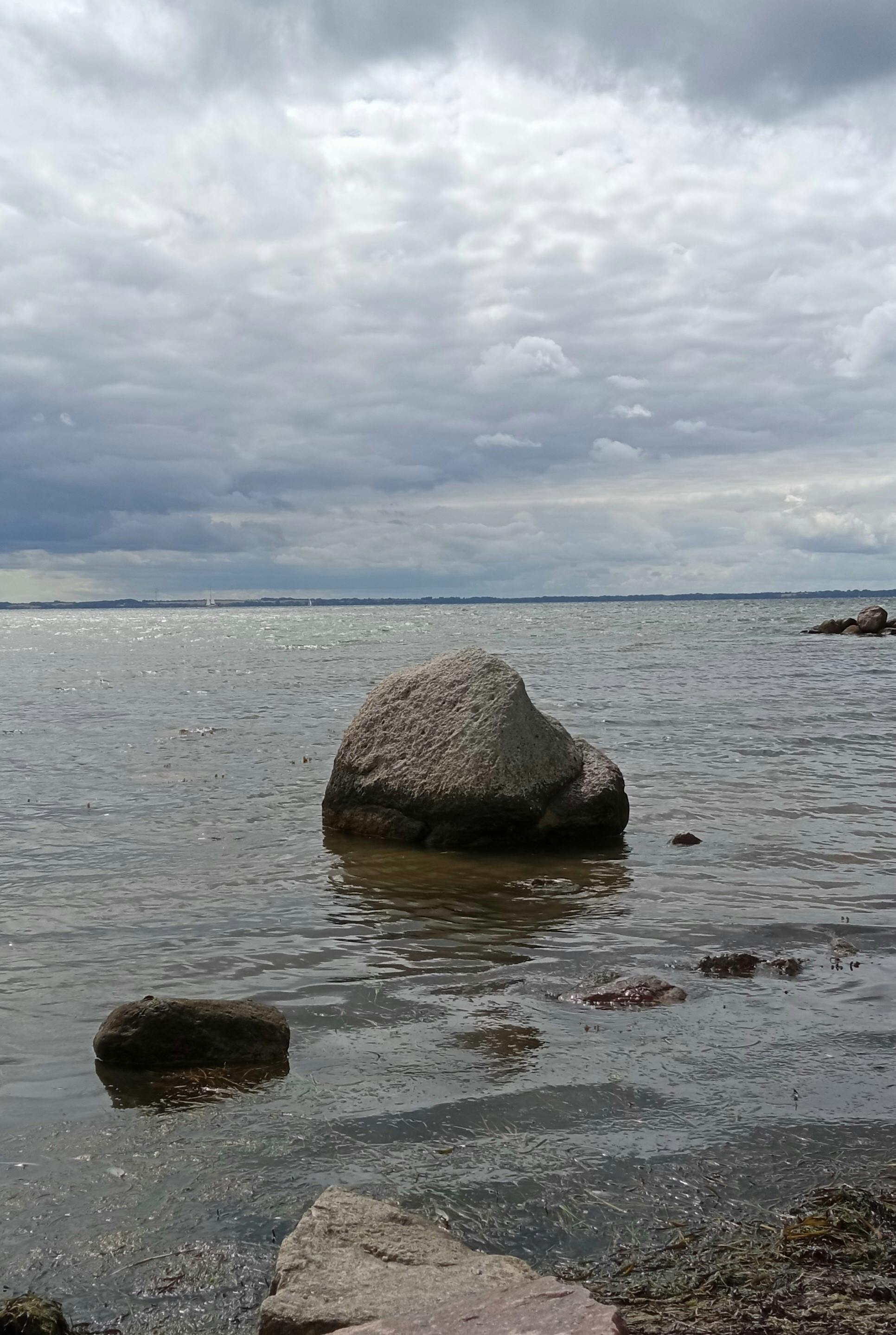 Rocks on the Ocean under the Cloudy Sky Free Stock Photo