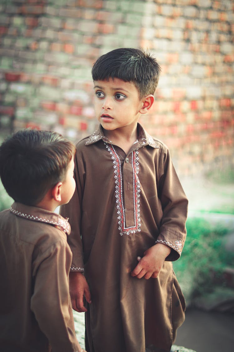 Close-Up Shot Of Two Boys In Traditional Clothing