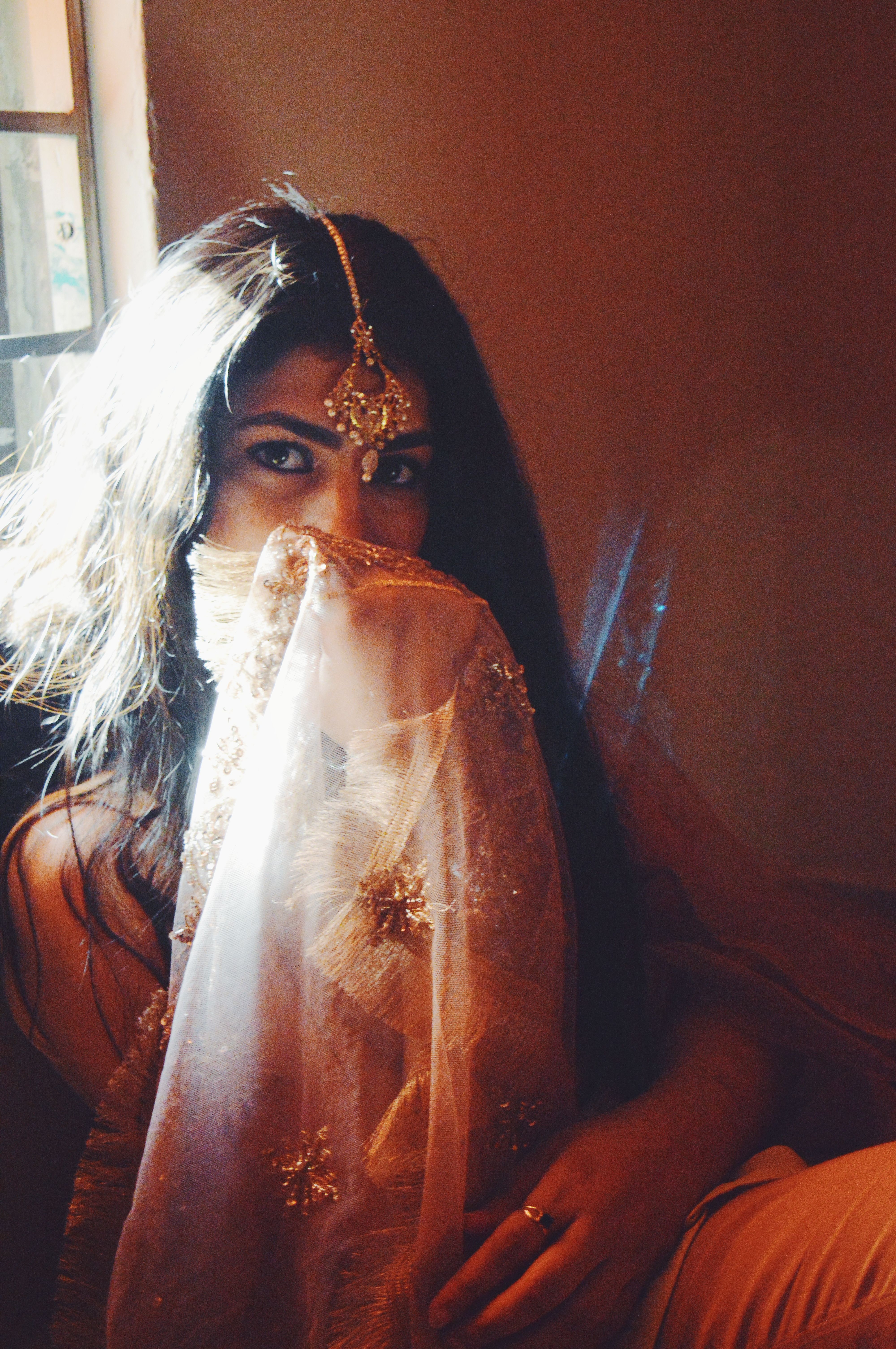Close-up portrait of a woman in traditional South Asian clothing with intricate adornments.