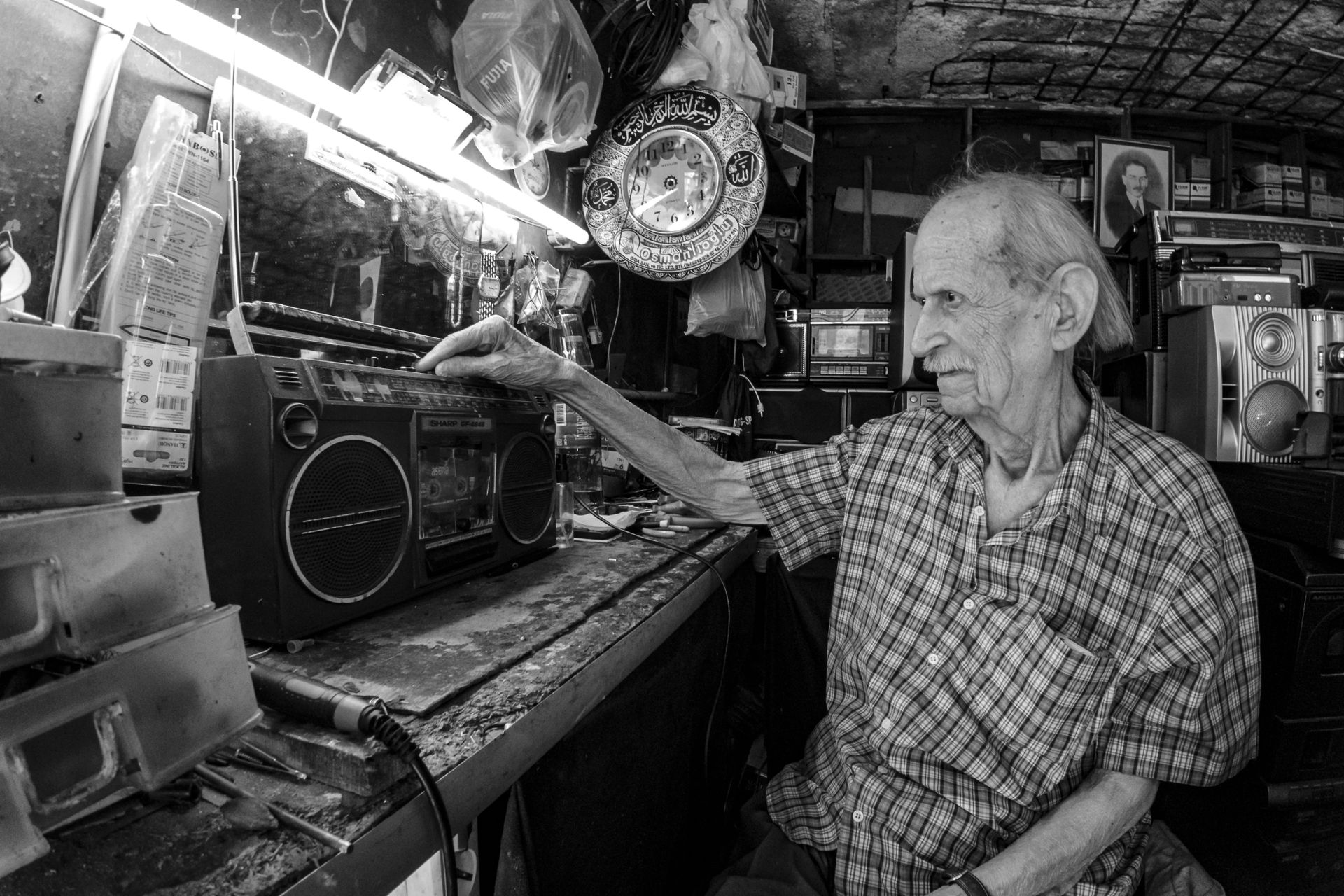 Elderly Man Repairing Radio in Workshop