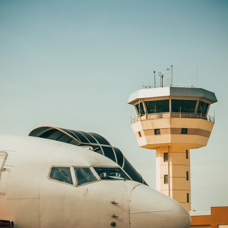 Airport Control Tower And A Front Of The Airplane