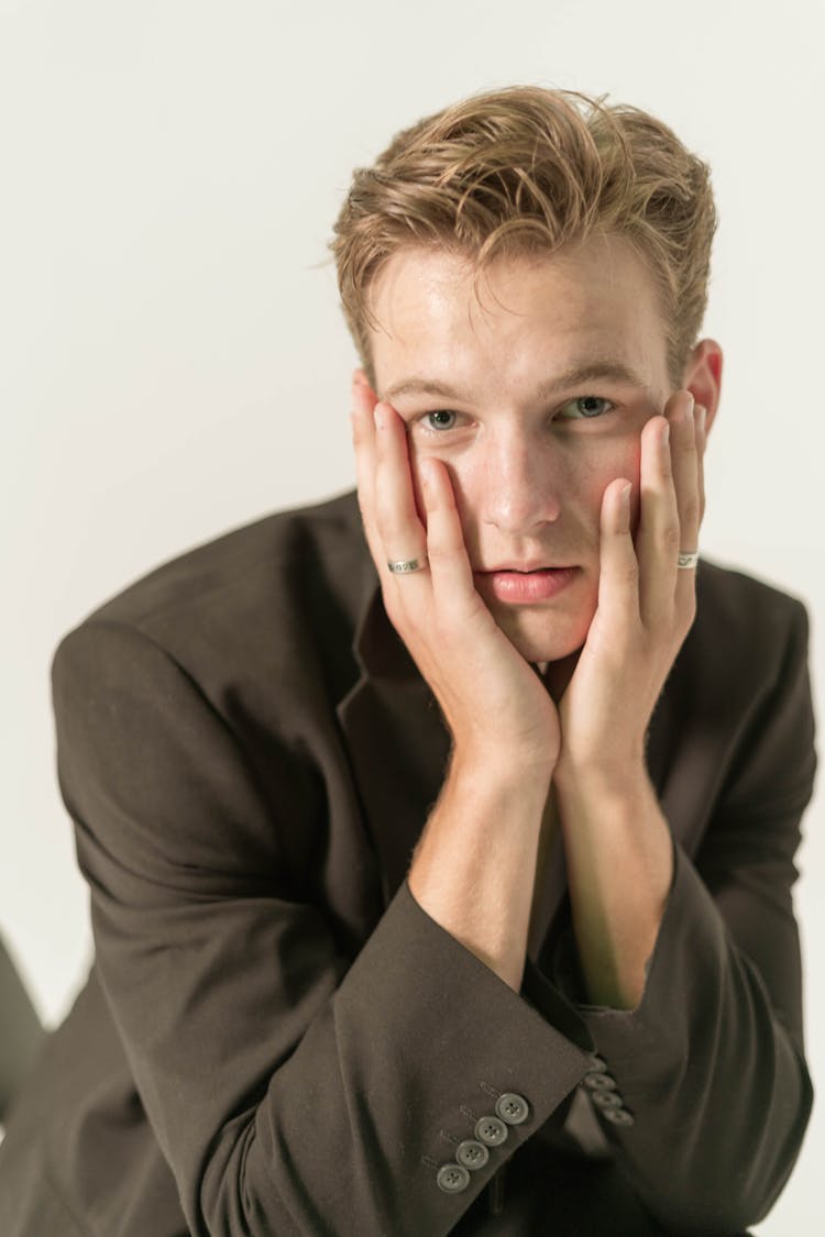 Blonde Model Man In Black Jacket Sitting With Head In Hands