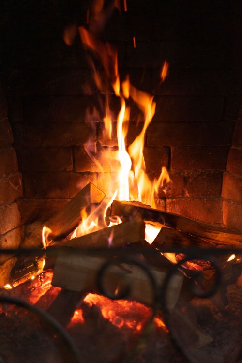 Free Warm and inviting fireplace with dancing flames in a cozy indoor setting. Stock Photo